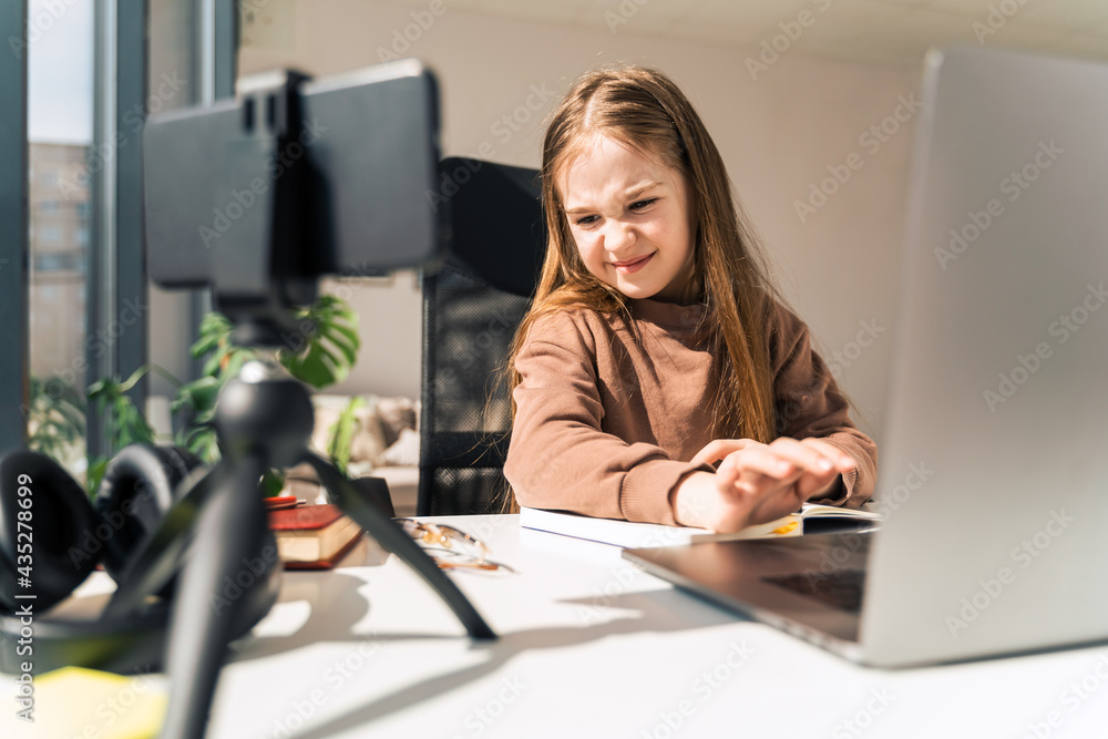 Little schoolgirl is engaged in distance learning at the computer Little schoolgirl is engaged in distance learning at the computer