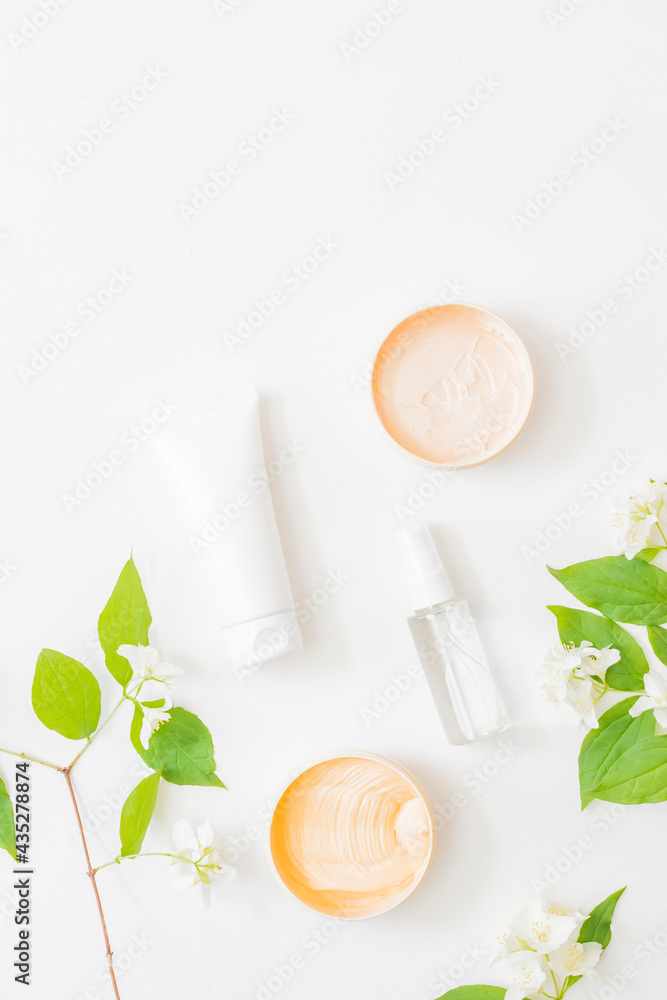 Flat lay composition with cosmetics and jasmine flowers on a light background Flat lay composition with cosmetics and jasmine flowers on a light background