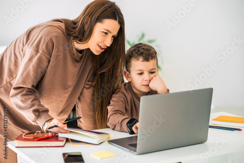 Mother helps her son with online distance education