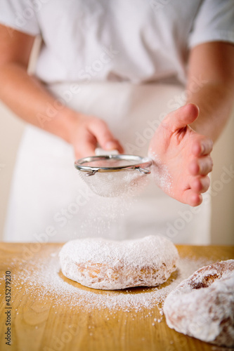 Sifting powered sugar on donut