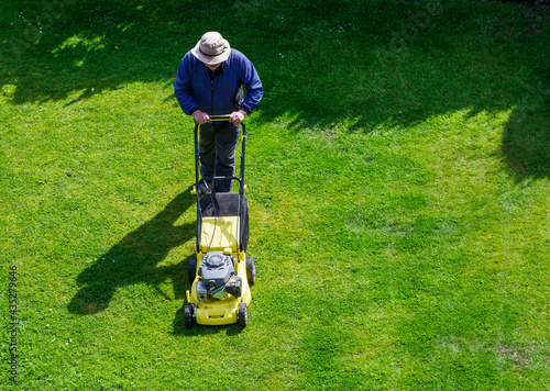 man tending his garden by cutting the grass