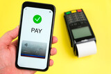 Contactless payment application on the screen of smartphone and pos terminal on the yellow background. 
