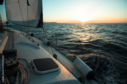 Yacht boat in the open Sea during amazing sunset. Luxury Sailing.