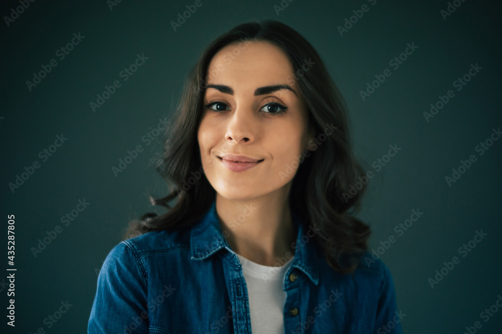 Close up portrait of a confident attractive young brunette woman on gray wall background Close up portrait of a confident attractive young brunette woman on gray wall background