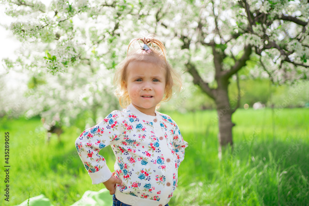 little girl stands in a flowering spring garden. seasonal allergies in children little girl stands in a flowering spring garden. seasonal allergies in children