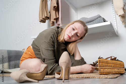 Stressed unhappy young European female looking to stylish shoes and crying out loud because she can't afford any of them. Frustrated girl having sad and painful look as she has nothing to wear
