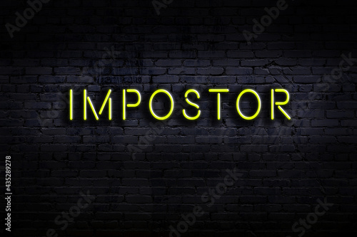 Foto Night view of neon sign on brick wall with inscription impostor