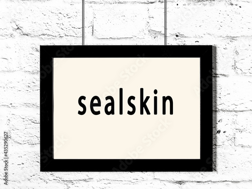 Tableau sur toile Black frame hanging on white brick wall with inscription sealskin