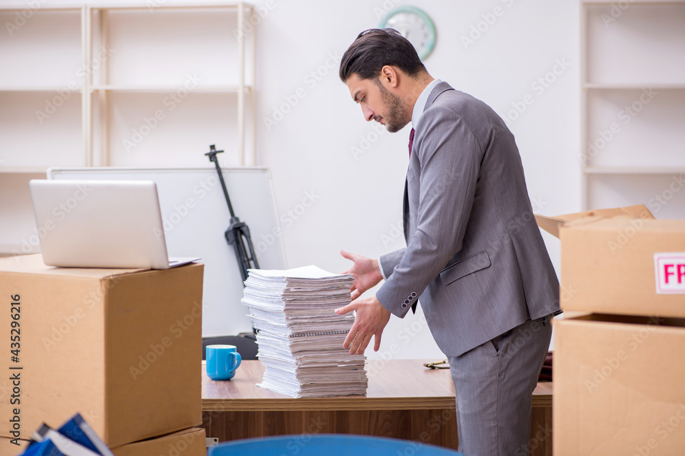 Young male employee in relocation concept Young male employee in relocation concept