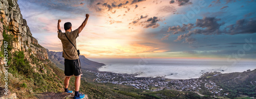 Victory and success after a hike up Table Mountain at sunset. Looking over the bay with colourful enhanced sunset - Great outdoors adventure and travel holiday destination, Cape Town, South Africa