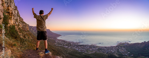 Victory and success after a hike up Table Mountain at sunset with clear skies looking over the bay - Great outdoors adventure and travel holiday destination, Cape Town, South Africa