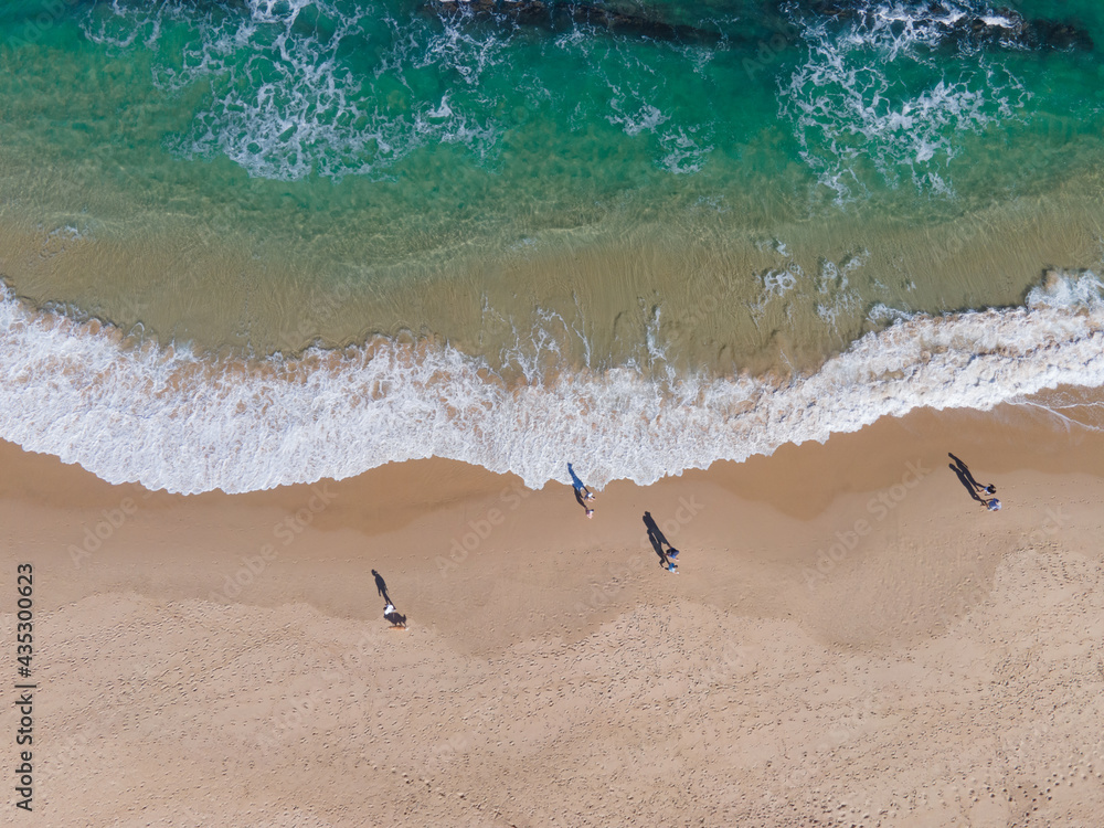 Aerial view of people walking along coastline Aerial view of people walking along coastline