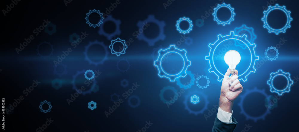 Abstract dark wallpaper with copyspace and man hand with light bulb and digital gears around, idea concept. Mock up Abstract dark wallpaper with copyspace and man hand with light bulb and digital gears around, idea concept. Mock up