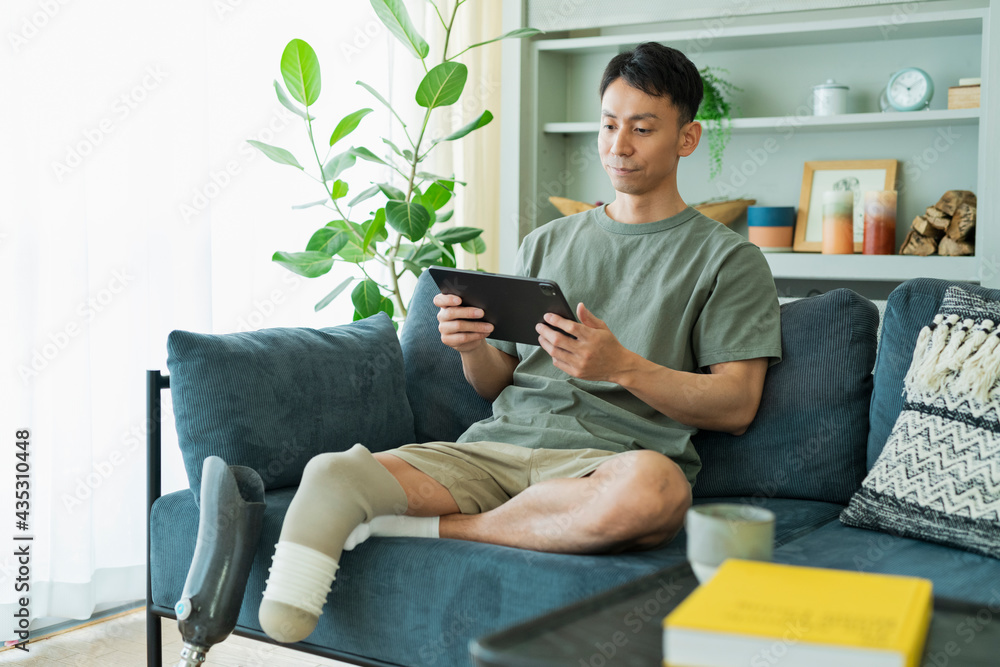 Obraz premium ソファでくつろぐ義足の男性