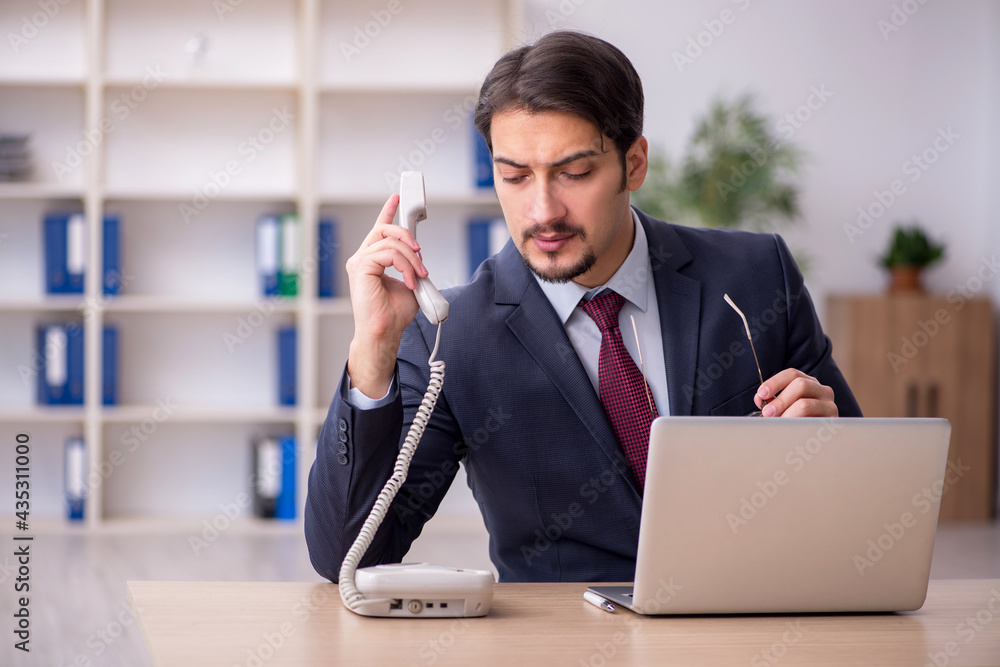 Fototapeta premium Young male employee working in the office