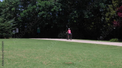 Silver comet trail - Female rides by on a bike on a paved trail
