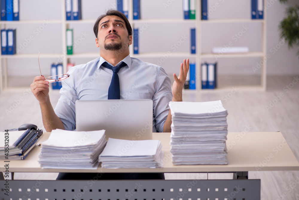 Young businessman employee unhappy with excessive work in the of Young businessman employee unhappy with excessive work in the of
