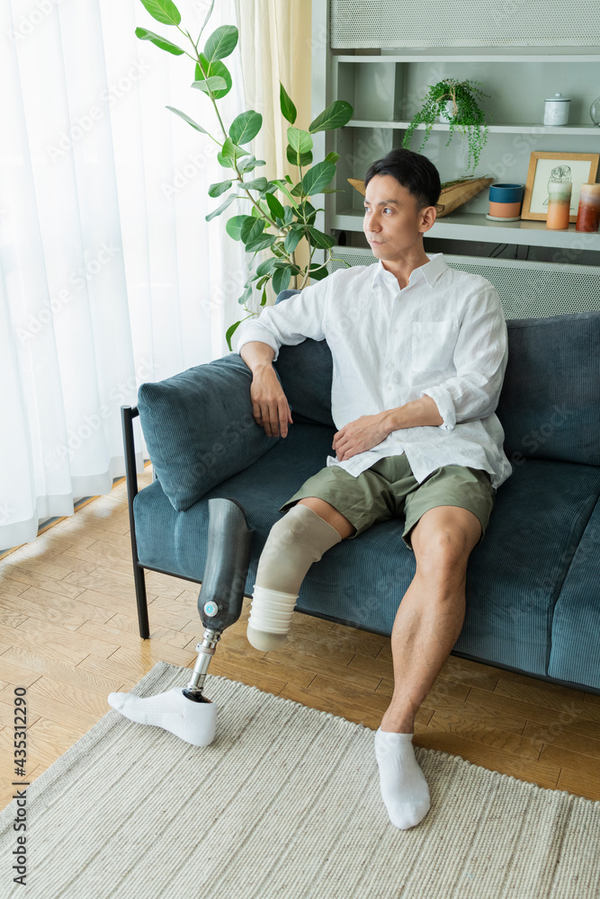 Fototapeta premium ソファでくつろぐ義足の男性