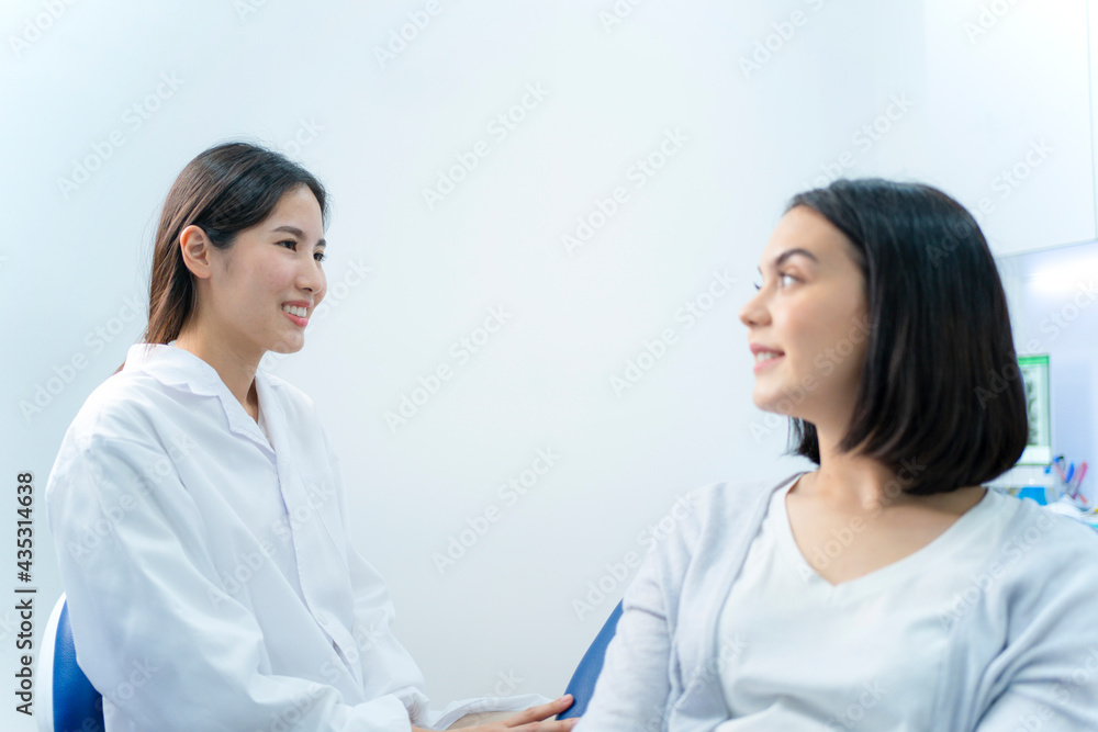 Asian female dentist giving an advice for oral treatment to patient.