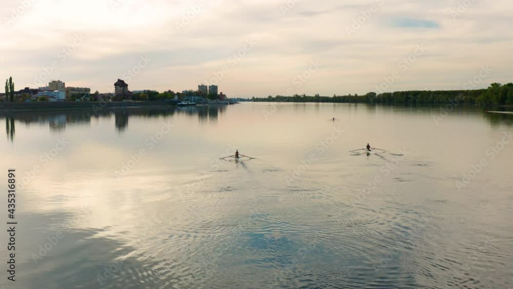 People rowing their boats and sees the beautiful sunset in Danube River, Vukovar Croatia. Aerial People rowing their boats and sees the beautiful sunset in Danube River, Vukovar Croatia. Aerial
