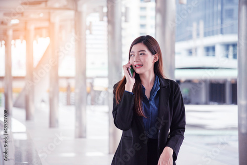 Business woman using smartphone shopping online, call, texting message internet technology lifestyle. Asian woman using cellphone walking on city street. Smart phone smart confident woman modern city