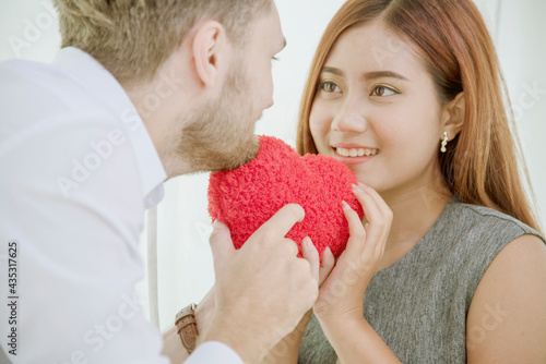 Couple lover in love smile and looking eyes each other with happiness romantic relationship. Couple lover holding red heart shape symbol of love. Close up face shot love at first sight flirting date © aFotostock