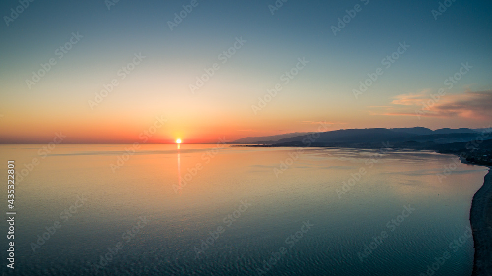 Obraz premium Sunset over a calm sea from the height of bird flight