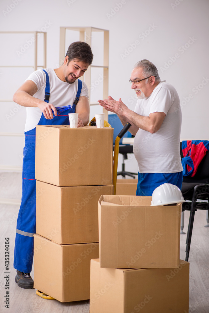 Two male professional movers drinking alcohol during break Two male professional movers drinking alcohol during break