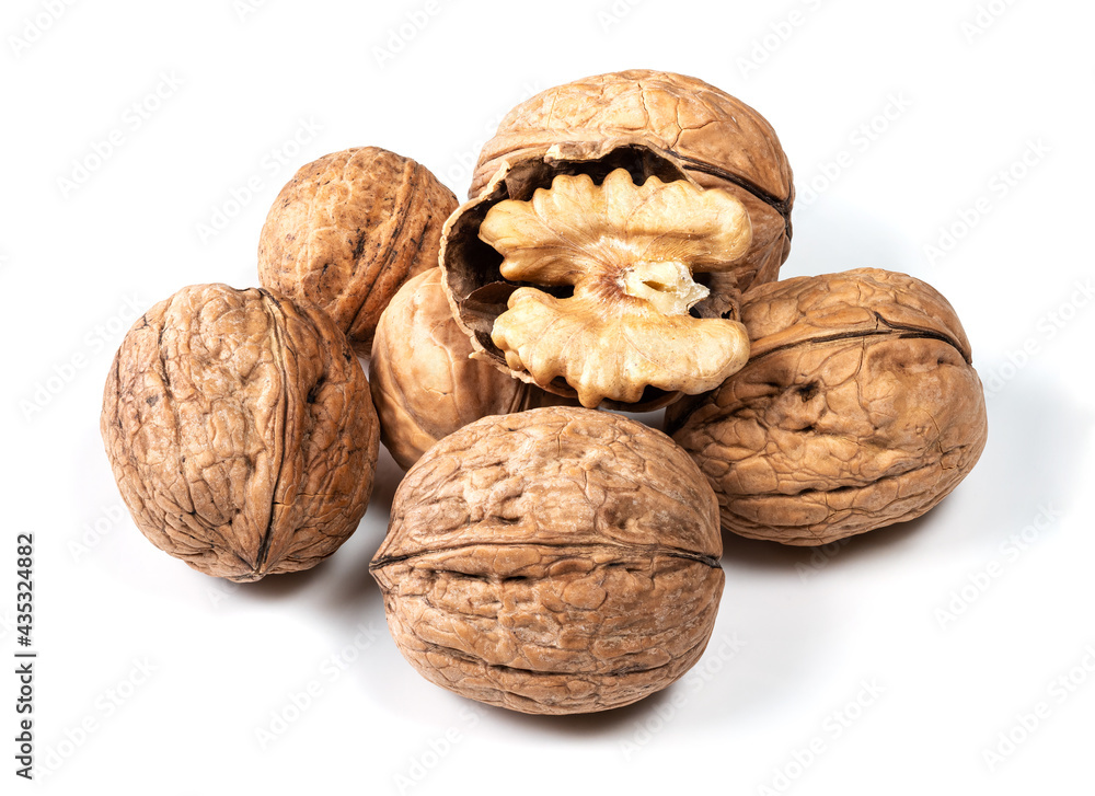 several whole and shelled walnuts on white several whole and shelled walnuts on white