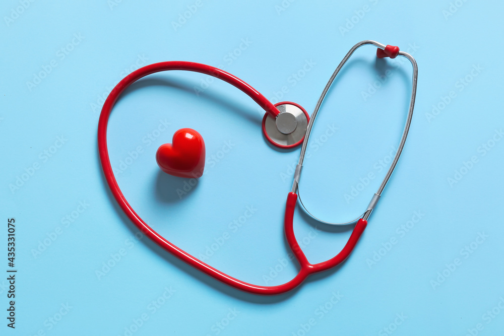 Modern stethoscope and red heart on color background Modern stethoscope and red heart on color background
