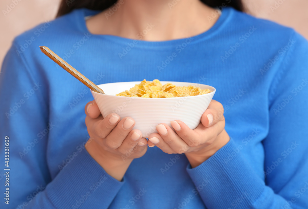 Young woman and bowl with cornflakes, closeup