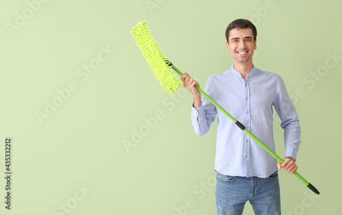 Young man with floor mop on...