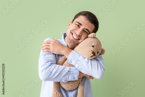 Young man hugging teddy bea...