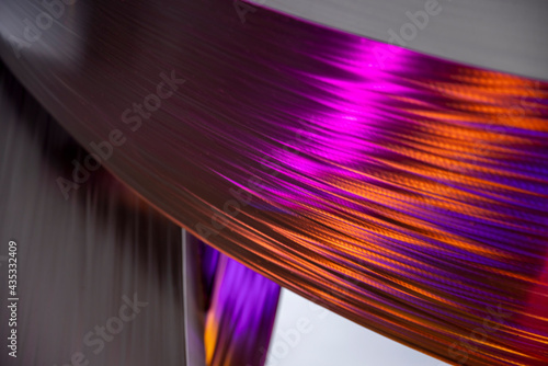Abstract purple pink and orange swooshed colors on brushed metal