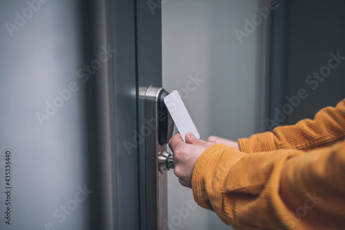 Close up of mans hand opening the door with an access card
