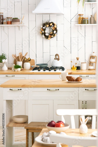 White kitchen interior with a plant on a wooden countertop. New modern kitchen interior. Minimalism