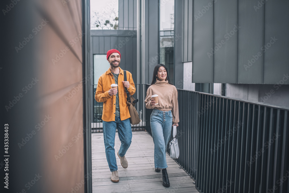 Young man and woman in casual clothes walking together