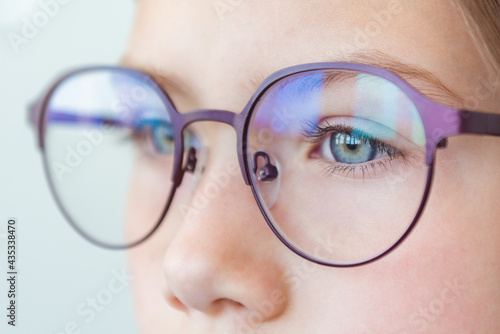 Health care, eyeball check, clear vision concept. Close up portrait of pensive schoolgirl in new glasses