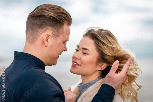 Two Young couple standing enjoying on a sand and enjoying each other.Summer,spring,autumn vacation.Closeup. © ARVD73