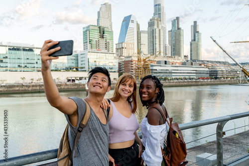 Young friends taking selfies at the riverside