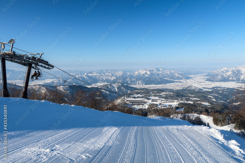 天気の良い日本のスキーリゾートでスキーをする人