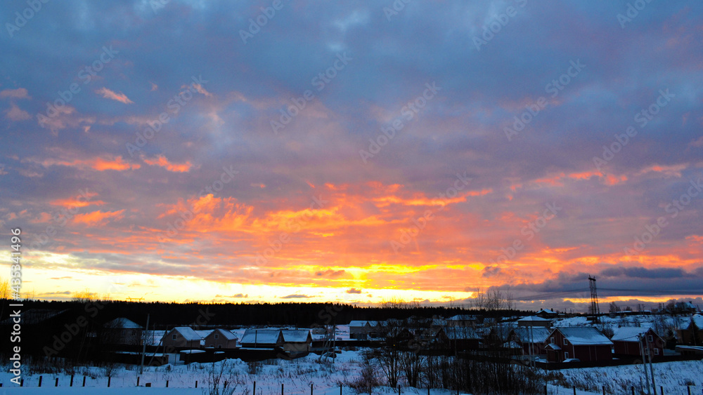 Bright multicolored sunset and dark clouds over the countryside