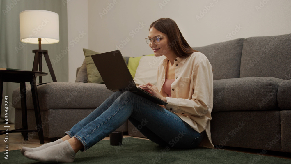 European girl texting someone while sitting on the floor. European girl texting someone while sitting on the floor.