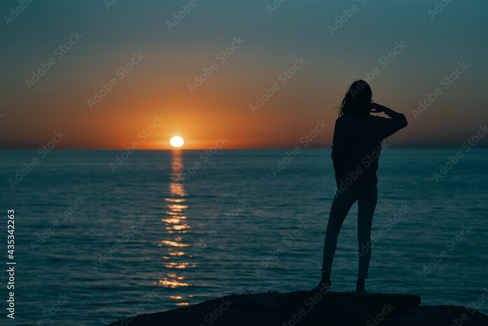 woman gesturing with her hands and sunset sea landscape beach