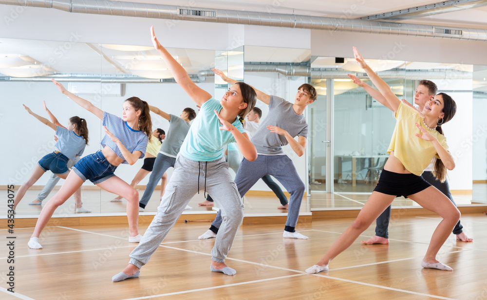 Obraz premium Dancing group of five teenagers practicing new dance in studio