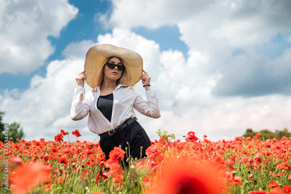 Beautiful ukrainian lady alone at flowers poppies field, sunny day