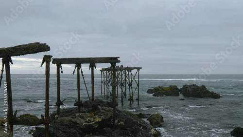 Ruins of the historic, 120-year-old dock in Llico, Vichuquen, Chile, wide shot photo