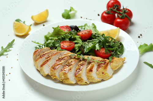 Concept of tasty eating with salad with grilled chicken on white background