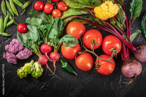 Healthy diet background. Many fresh vegetables  shot from the top on a black background. Summer salad ingredients