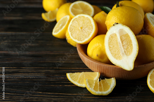 Ripe lemons on wooden background, space for text
